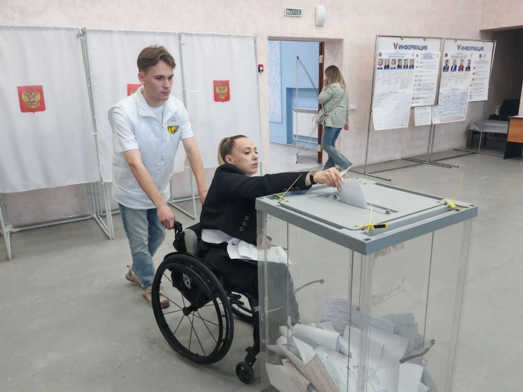 Волонтёры помогают маломобильным избирателям на участке в Бокине
